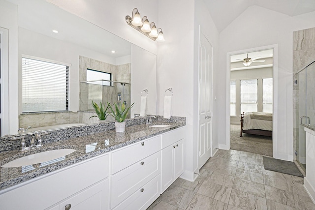 bathroom with connected bathroom, a sink, baseboards, vaulted ceiling, and a stall shower