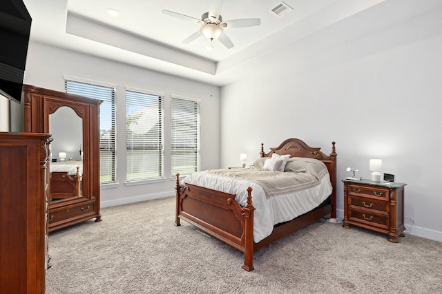 bedroom featuring a tray ceiling, ceiling fan, and light colored carpet