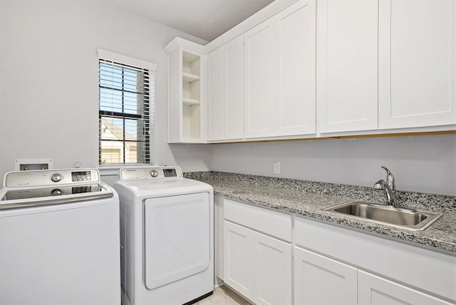 washroom with sink, washer and dryer, and cabinets