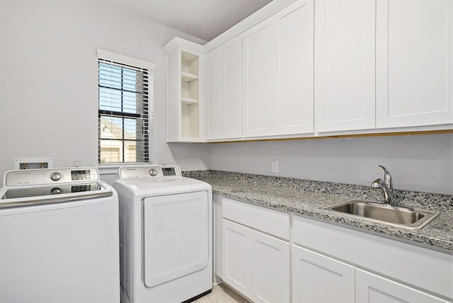 washroom featuring cabinet space, a sink, and washer and clothes dryer