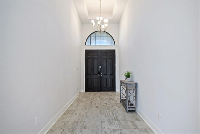 entryway featuring an inviting chandelier and a high ceiling