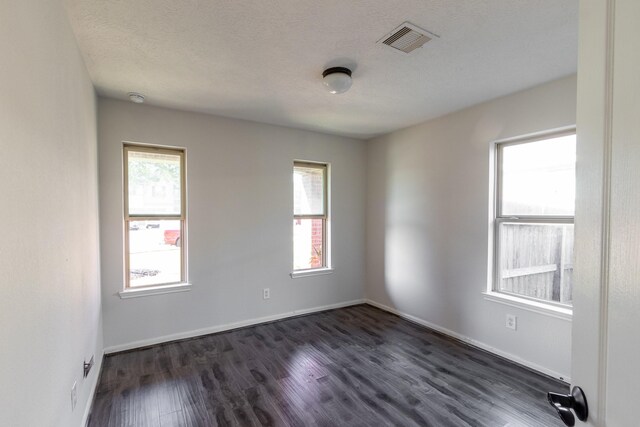 unfurnished room featuring a textured ceiling and dark hardwood / wood-style flooring