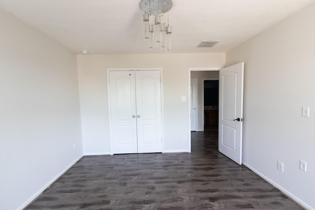 unfurnished bedroom featuring a closet and dark hardwood / wood-style flooring