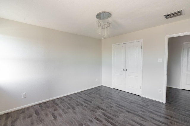 unfurnished bedroom featuring a closet and dark hardwood / wood-style floors