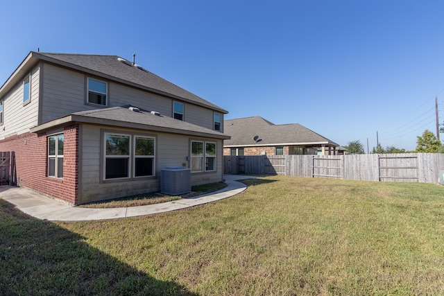 back of property with a lawn and central air condition unit