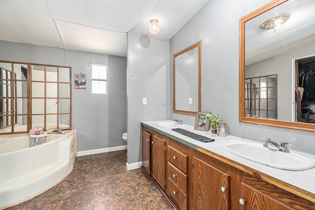 bathroom with a tub, vanity, and toilet