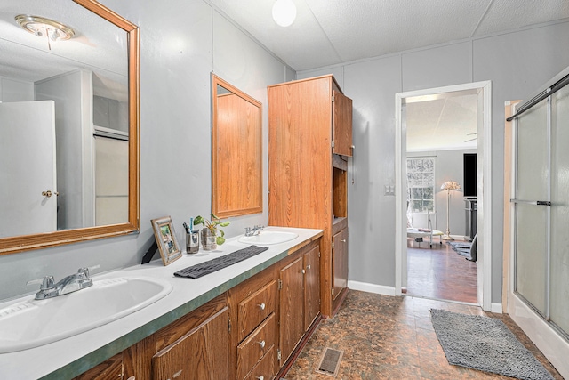 bathroom with vanity, a textured ceiling, and walk in shower