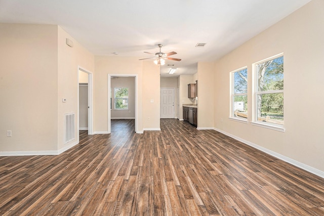 unfurnished living room featuring dark hardwood / wood-style floors, ceiling fan, and sink