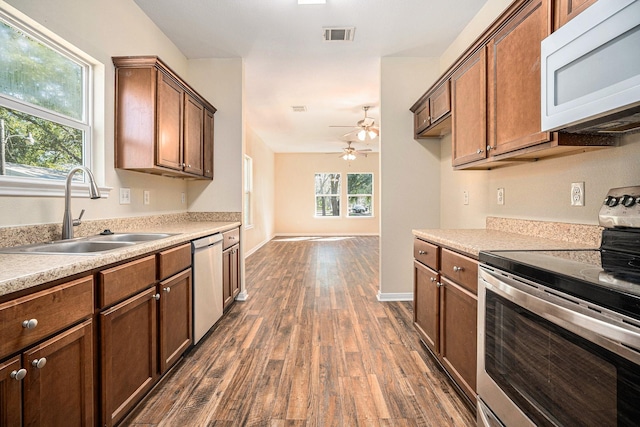 kitchen featuring dark hardwood / wood-style flooring, stainless steel appliances, ceiling fan, and sink