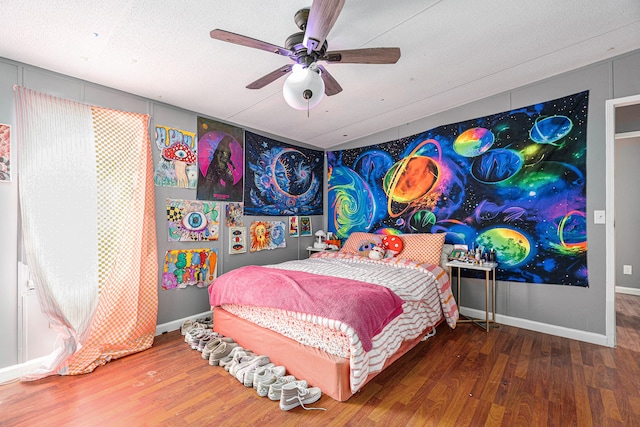 bedroom with wood-type flooring, a textured ceiling, and ceiling fan