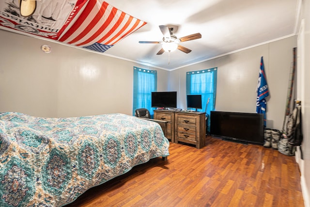 bedroom with hardwood / wood-style flooring, ceiling fan, and crown molding