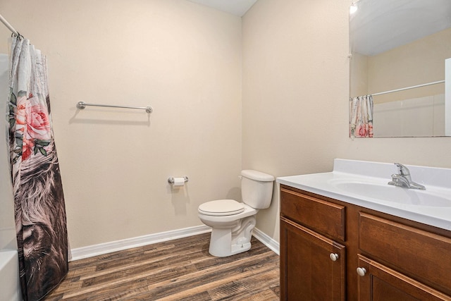 full bathroom featuring hardwood / wood-style floors, vanity, toilet, and shower / bath combo with shower curtain