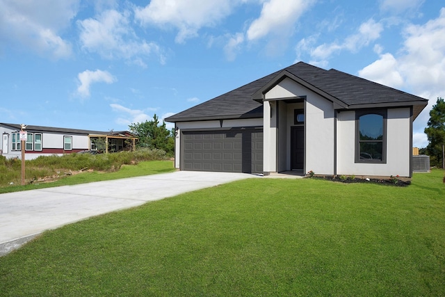 view of front of property featuring a front yard, a garage, and central AC unit