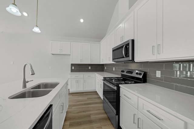 kitchen with pendant lighting, sink, white cabinetry, appliances with stainless steel finishes, and dark hardwood / wood-style flooring