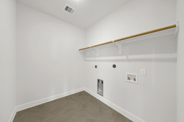 clothes washing area featuring dark tile patterned flooring, hookup for an electric dryer, and hookup for a washing machine