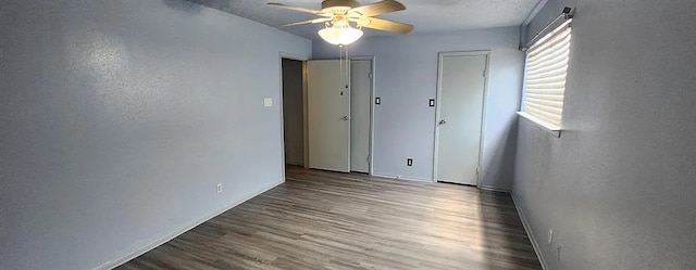 empty room with ceiling fan and hardwood / wood-style floors