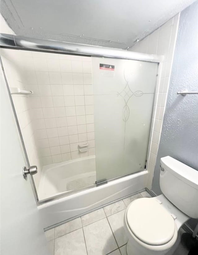 bathroom with tile patterned floors, toilet, and enclosed tub / shower combo