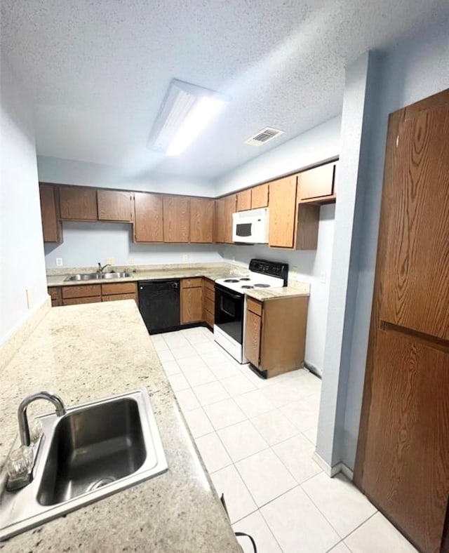 kitchen featuring light tile patterned floors, a textured ceiling, sink, and white appliances