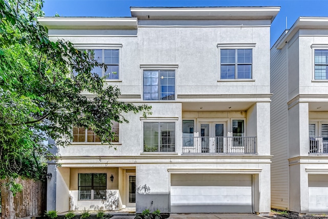 view of property with a balcony and a garage