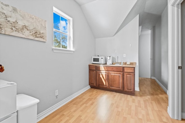 bathroom featuring hardwood / wood-style floors, toilet, vaulted ceiling, and vanity