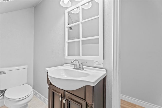 bathroom with hardwood / wood-style floors, vanity, and toilet