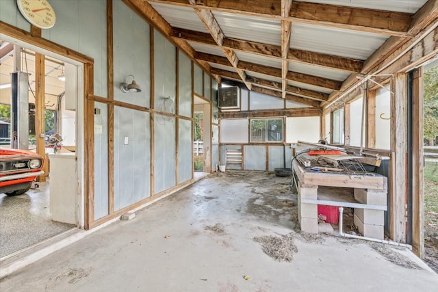 miscellaneous room featuring plenty of natural light, vaulted ceiling, and concrete floors