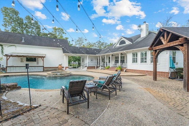 view of swimming pool featuring an in ground hot tub and a patio area