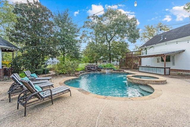 view of swimming pool featuring an in ground hot tub and a patio area