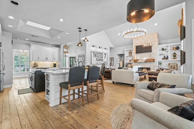 kitchen featuring white cabinets, light hardwood / wood-style flooring, hanging light fixtures, and a center island