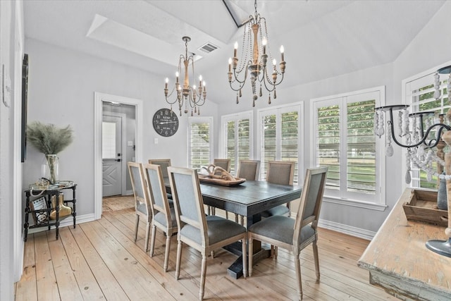 dining space featuring an inviting chandelier, light hardwood / wood-style floors, and high vaulted ceiling