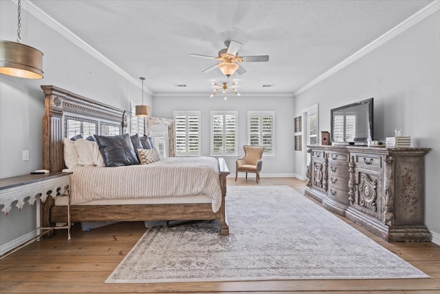 bedroom with ornamental molding, ceiling fan, a textured ceiling, and light hardwood / wood-style flooring