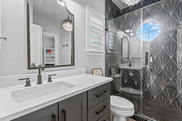 bathroom featuring plenty of natural light, tiled shower, vanity, and toilet