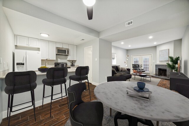 dining area with ceiling fan and dark wood-type flooring