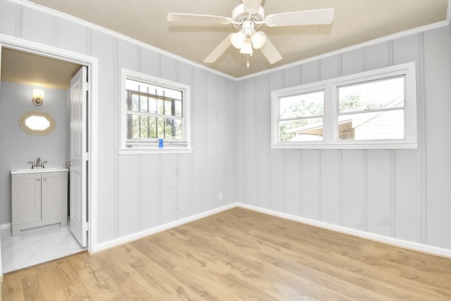 spare room with ornamental molding, ceiling fan, light hardwood / wood-style flooring, and sink