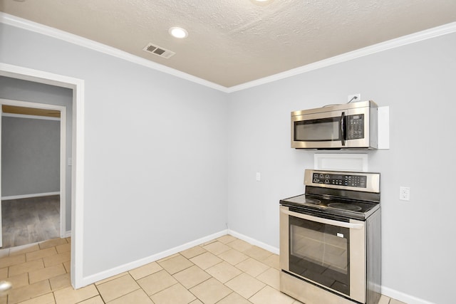 kitchen with light tile patterned floors, a textured ceiling, appliances with stainless steel finishes, and ornamental molding