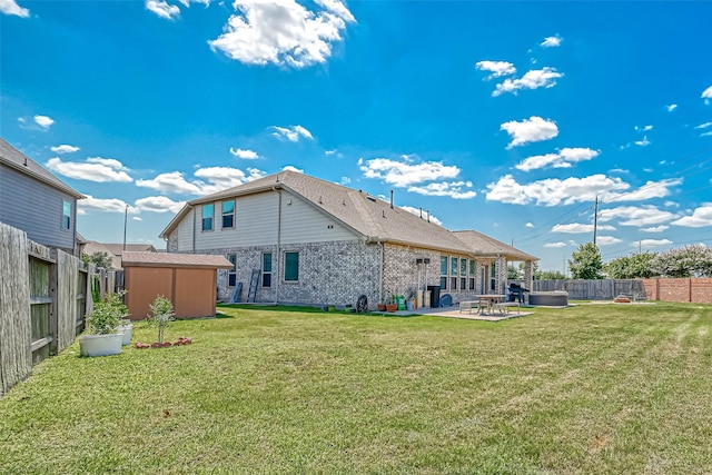 back of house with a patio, a yard, and a shed