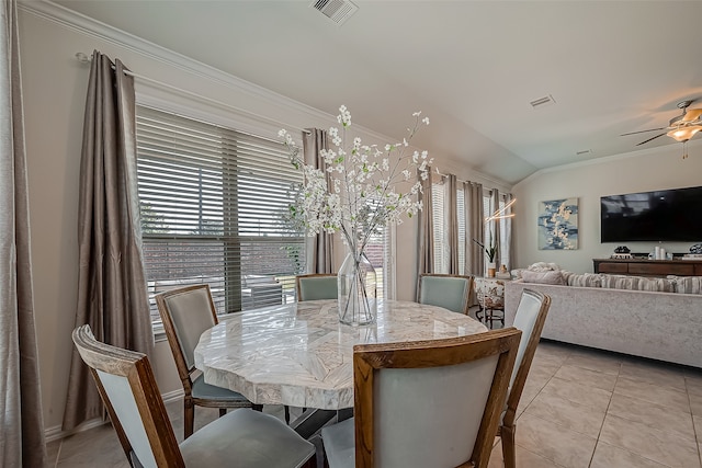 dining room with lofted ceiling, ornamental molding, ceiling fan, and light tile patterned floors