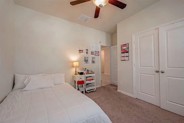 carpeted bedroom featuring ceiling fan and a closet