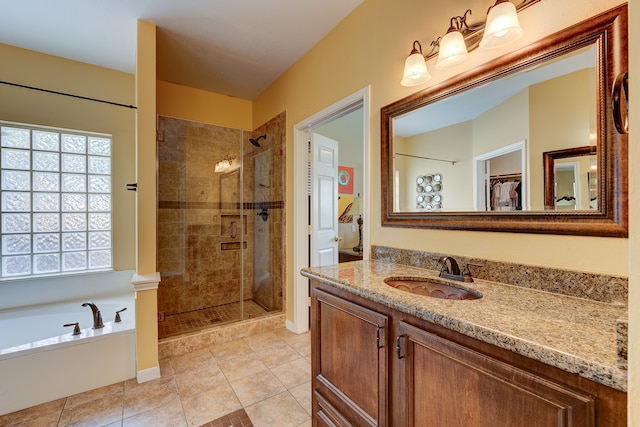 bathroom with tile patterned flooring, shower with separate bathtub, and vanity