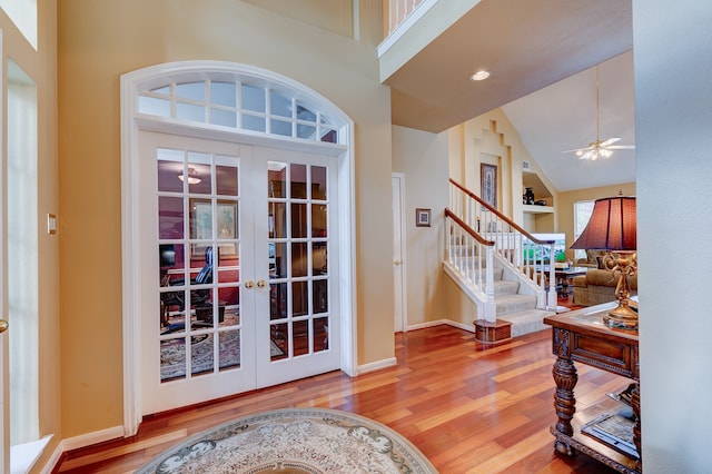 entryway with ceiling fan, french doors, high vaulted ceiling, and hardwood / wood-style flooring