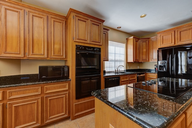 kitchen featuring sink, light tile patterned floors, dark stone countertops, a kitchen island, and black appliances