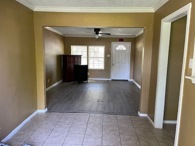 foyer with light wood-type flooring, crown molding, and ceiling fan