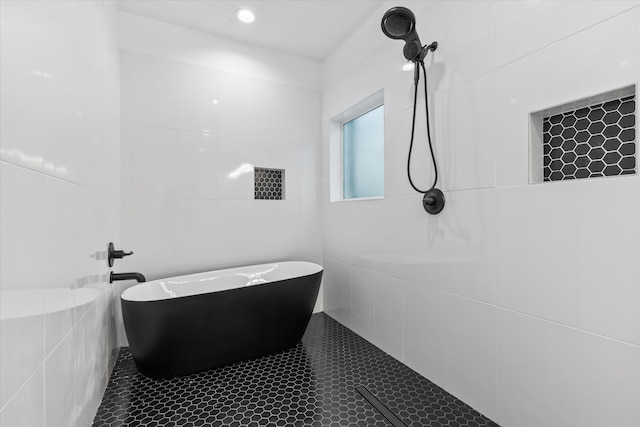 bathroom featuring plus walk in shower, tile walls, and tile patterned floors