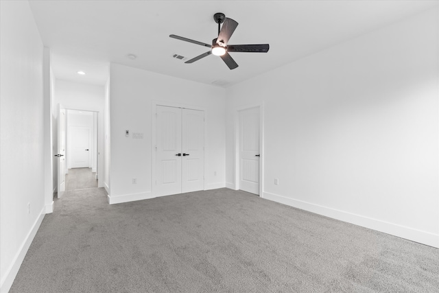 unfurnished bedroom featuring ceiling fan, a closet, and carpet flooring