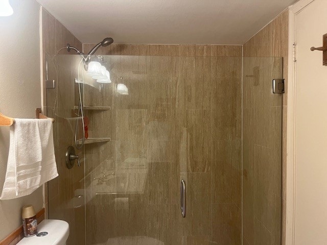 bathroom with walk in shower and toilet