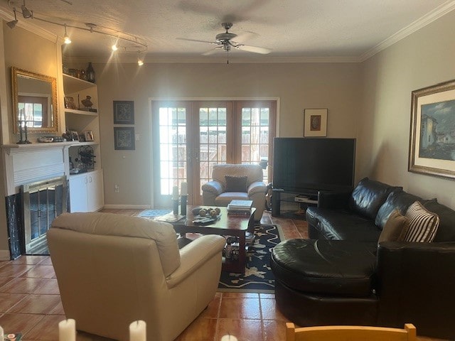 living room featuring a textured ceiling, light tile patterned floors, ornamental molding, and ceiling fan