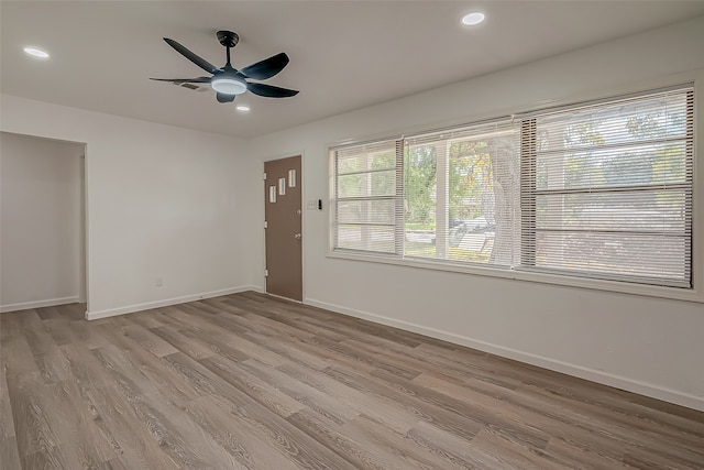 spare room with ceiling fan and light wood-type flooring