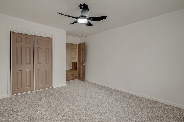 unfurnished bedroom featuring ceiling fan, light colored carpet, and a closet