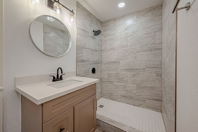 bathroom with vanity and tiled shower