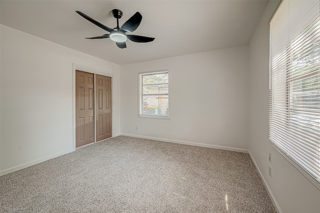 unfurnished bedroom featuring carpet flooring, ceiling fan, and a closet